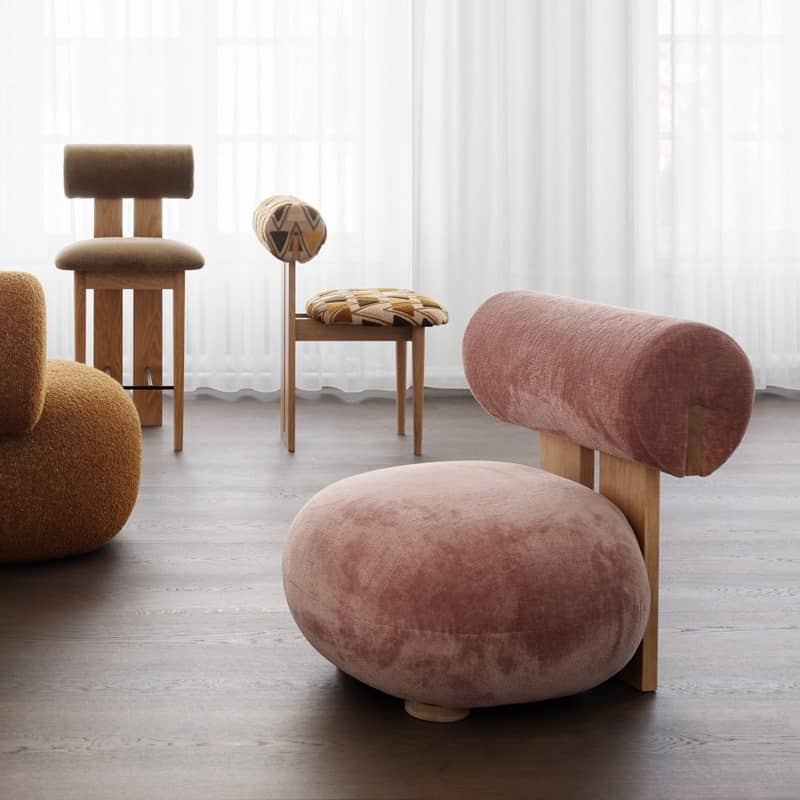 Ein rosaroter, abgerundeter Sessel steht im Wohnzimmer